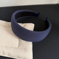 Detailed macro view of navy blue knitted wide headband with thick padded texture - Navy Blue