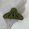 Detail view of olive green hollow fan-shaped hair claw clip with smooth glossy finish - Green