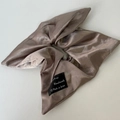 Detail van champagne satijnen scrunchie met handgemaakt label op witte ondergrond - Champagne Koffie