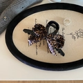 Retro leopard print bow hair claw clip for thick hair, shown on a stylish lifestyle background - Cross Claw Clip