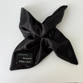 Detailed macro of a black satin hair scrunchie with a handmade in Korea brand label - Black