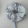 Détail du chouchou bleu clair à pois avec plis superposés et rubans fluides élégants - Bleu