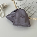 Macro view of luxurious purple silk eye mask featuring embossed camellia flower patterns - Grey Purple