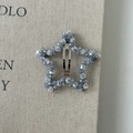 Detailed macro view of a light blue star-shaped crystal beaded hair clip on fabric - Grey-Blue Star