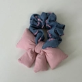 Detailed view of blue denim hair scrunchie with pink fringe and a large fabric bow - Pink Bow Style