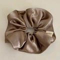 Detail of a brown satin scrunchie with a Hand Made tag on a minimalist grey background - Milk Tea Nude