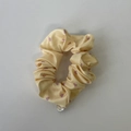 Detail eines gelben Satin-Scrunchies mit rosa Herzen und silbernem Metall-Anhänger - Gelbes Herz-Haargummi