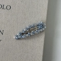 Detailed macro view of the silver BB hair clip with blue-gray crystals on linen texture - Grey-Blue Water Drop