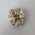 Detail eines großen beigen Scrunchies mit grünen Punkten und seidiger Satintextur - Grünes Punktiertes Haargummi