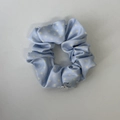 Details des hellblauen gepunkteten Satin-Haargummis mit einem silbernen Logo-Anhänger - Hellblaues Punktiertes Haargummi
