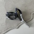 Dettaglio della pinza per capelli a tulipano con trama marmorizzata grigia e molla dorata - Stile Tulipano