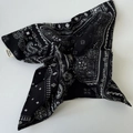 Macro view of navy blue paisley pattern fabric on a handmade bow hair scrunchie - Black Square Towel