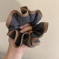 Primer plano de coletero grande en azul denim con detalles de bordes ondulados marrones - gris oscuro