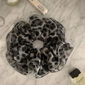 Dettaglio ravvicinato dell'elastico scrunchie leopardato con bordo rifinito di qualità - Stampa leopardata
