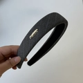 Detailed macro view of dark grey striped fabric headband with golden handmade metal plate - Headband