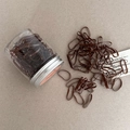 Detail view of durable brown high-elastic hair ties in a clear jar with a silver screw lid - Brown