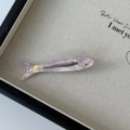 Detailed close-up of fish-shaped acetate hair clip with pearlescent purple finish and rhinestone - Pink Purple
