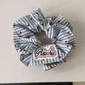 Dettaglio macro dell'etichetta Ruichu sull'elastico a quadretti blu con motivi a cuore - Scrunchie Sciancrato