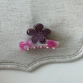 Détail d'une pince à cheveux rose marbré avec une fleur violette sur lin gris clair - Fleur rose-violet