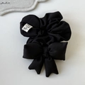 Elastico per capelli con fiocco nero e etichetta tessuta FMC su sfondo bianco pulito - Nero