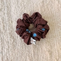 Dettaglio dell'elastico marrone a pois blu con una piccola etichetta in tessuto - Piccolo Elastico