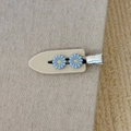 Dettaglio del fermaglio a becco d'anatra in acetato beige con fiori di margherita blu chiaro - Bianco con fiori blu