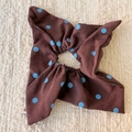Dettaglio di un elastico per capelli marrone a pois blu con trama di seta su tessuto - Scrunchie Stile Foulard
