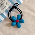 Blue floral hair tie with glossy petals and strong elastic band on beige fabric - Hair Tie Style