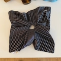 Détail de l'étiquette tissée fait main sur un grand chouchou en tissu à pois noirs et blancs - Style Foulard Noir