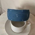 Close-up of blue denim headband with white embroidery patterns on a ceramic cup - Light Blue