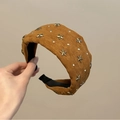 Dettaglio di cerchietto largo con rivetti a stella in bronzo e strass su camoscio marrone - Caffè Scuro