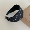 Dettaglio di un cerchietto vintage nero con borchie a stella in bronzo e velluto - Nero