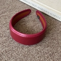 Close-up of burgundy leather headband with precise stitching and anti-slip lining detail - Burgundy