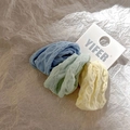 Close-up of three elastic hair ties with textured diamond pattern in soft pastel colors - Sea Salt Blue