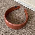 Detail of brown wide leather headband featuring fine stitching and premium texture - Brown
