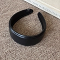 Close-up of black vintage leather headband with fine stitching and smooth grain texture - Black