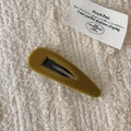 Pasador de pelo de terciopelo verde oliva con clip de metal sobre fondo de tela beige - Estilo Gota de Agua / Amarillo jengibre