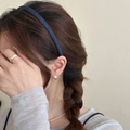 Detailansicht von Denim-Haarband mit silbernen Spiralohrringen und Perlenkette am Modell - Feiner Stil