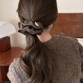 Detailed close-up of a large brown vintage fabric scrunchie with soft ruffled edges - Brown