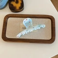 Detail of light blue acetate hair claw clip with colorful rhinestones on a tray - Blue