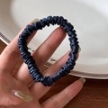 Detailed view of dark blue satin silk scrunchie with shiny pleated texture and high elasticity - Navy Blue