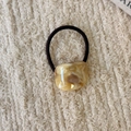 Close-up of amber marble resin hair tie with France Handmade gold lettering detail - Milk Coffee