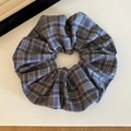Dettaglio dell'elastico per capelli a quadri blu e marroni con etichetta tessuta - Scrunchie a Quadri Blu Grigio