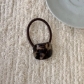 Vue détaillée de l'élastique à cheveux motif écaille de tortue sur tissu en lin beige - Écaille Café