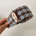 Detail view of plaid fabric headband with brown bow and embroidered puppy tag - Coffee Plaid Wide Headband