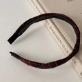 Detail of red and black tartan plaid headband with anti-slip inner teeth over beige book - Red Plaid Twist Style