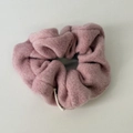 Dettaglio di un elastico per capelli rosa in peluche con spessa trama in lana d'agnello - Rosa