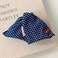Détail d'une pince à cheveux à pois bleus avec étiquette faite main et bouton - Style à Pois