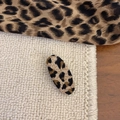 Close-up of leopard print fabric hair clip on a soft white knitted texture background - Leopard Small Oval Style
