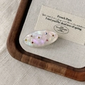 Close-up of oval acetate hair clip with iridescent finish and colorful gemstones - Mermaid Color